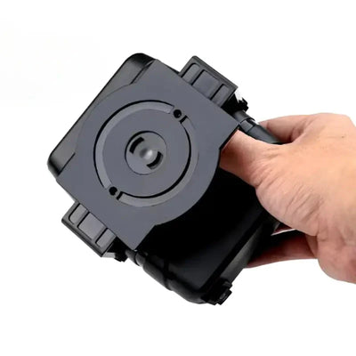 Eine Hand hält eine kompakte, schwarze Autoheizung mit 360-Grad-Drehgelenk.