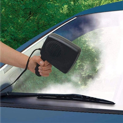 Eine Hand hält eine tragbare 12V Auto-Heizung an die Windschutzscheibe, um diese von Eis oder Beschlag zu befreien.