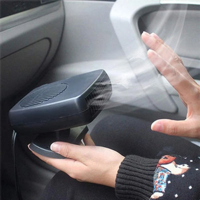 Eine Person hält eine tragbare 12V-Autoheizung in der Hand, die warme Luft in den Fahrzeuginnenraum bläst.