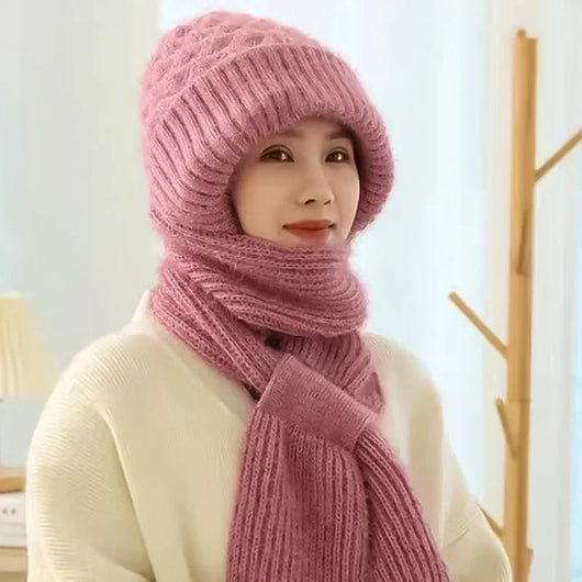 Eine Frau trägt eine rosa Wintermütze mit Ohrenschutz und integriertem Schal, die winddicht und warm ist.
