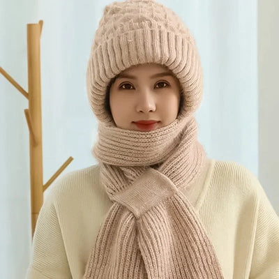 Frau trägt eine beige Wintermütze mit Ohrenschutz und passendem Schal, die vor Kälte schützt.