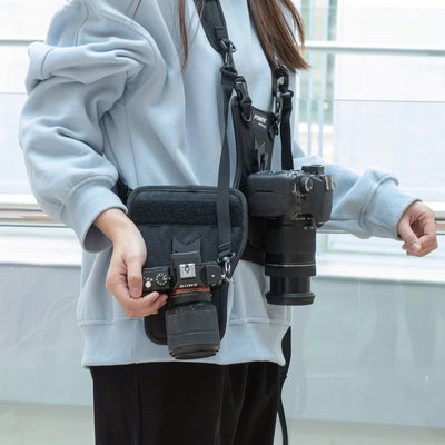 Doppelkamera-Gurt für Fotografen mit seitlichem Holster und Nylon-Mesh, an dem zwei Kameras befestigt sind.