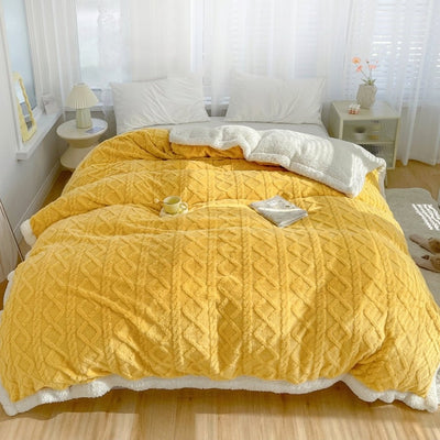 Gelbe Fleecedecke mit Lammwolle auf einem Bett in einem hellen Schlafzimmer