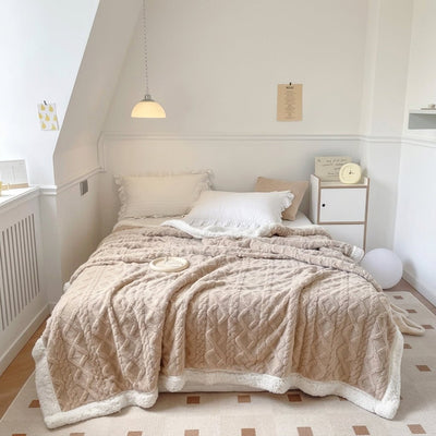 Beige Fleecedecke mit Lammwolle auf einem Bett in einem hellen, gemütlichen Schlafzimmer