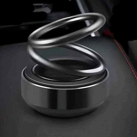 Ein moderner, metallischer kinetischer Molekularheizer mit rotierenden Ringen auf einer dunklen Oberfläche.