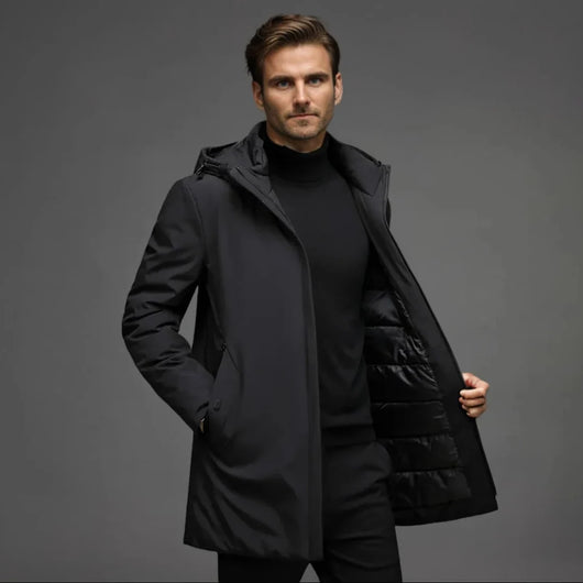 Ein Mann trägt einen wasserdichten, gefütterten Winterparka in Schwarz mit Kapuze und praktischen Taschen.