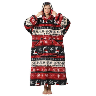 Eine Frau trägt eine übergroße Kapuzendecke mit weihnachtlichem Rentier- und Schneeflockenmuster, Fleece und Kängurutasche.
