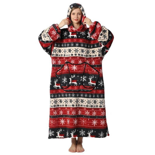 Eine Frau trägt eine übergroße Kapuzendecke mit weihnachtlichem Rentier- und Schneeflockenmuster, Fleece und Kängurutasche.