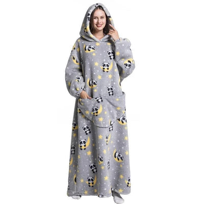 Eine Frau trägt eine graue Kapuzendecke in Übergröße mit Panda- und Mondmuster, Kängurutasche und elastischen Bündchen.