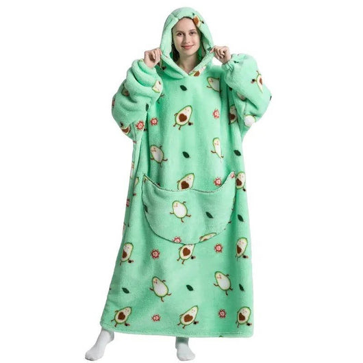 Eine Frau trägt eine übergroße Kapuzendecke mit Avocado-Muster, Fleece-Futter und einer großen Kängurutasche.