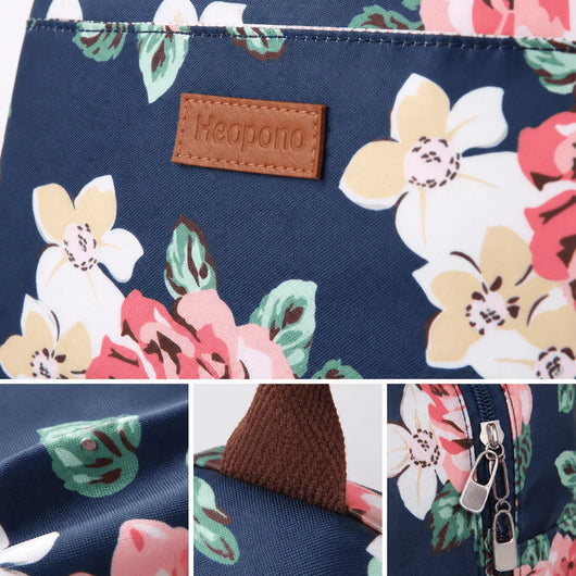 Detailansicht einer kleinen, blauen Kühltasche mit Blumenmuster, braunem Markenlogo und Reißverschluss.