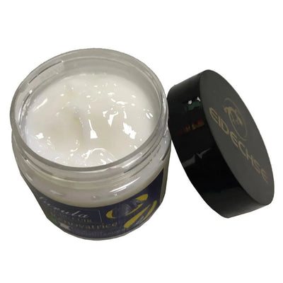 Ein offener Tiegel mit weißer Lederpflegecreme und daneben liegendem schwarzen Deckel mit Eidechsen-Logo.
