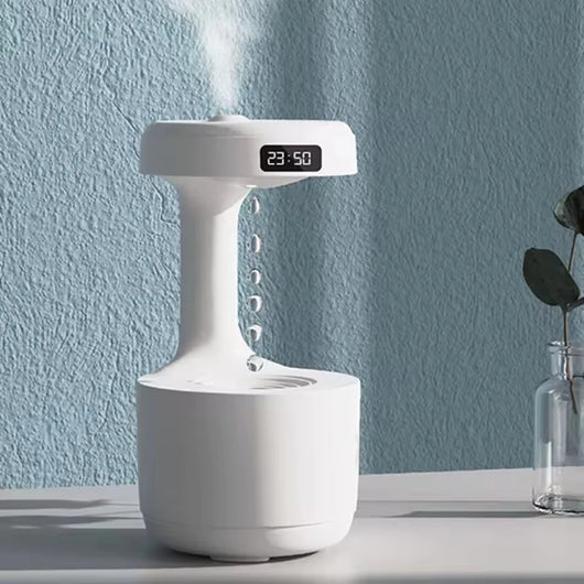 Moderner Luftbefeuchter für das Schlafzimmer mit digitaler Zeitanzeige und Wassertropfen-Effekt auf einem Tisch.