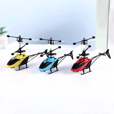 Drei kleine ferngesteuerte Hubschrauber in Gelb, Blau und Rot stehen nebeneinander auf einer weißen Oberfläche.