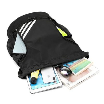 Sportrucksack für Herren mit Ballfach, gefüllt mit Tablet, Smartphone, Sonnenbrille und Magazin.