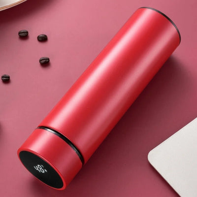 Rote Thermosflasche aus Edelstahl mit LED-Temperaturanzeige auf dem Deckel, neben Kaffeebohnen auf einem Tisch.
