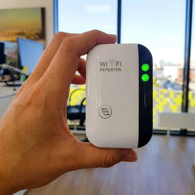 Ein weißer WLAN-Repeater mit leuchtenden grünen LEDs wird in einer Hand gehalten.