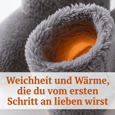 Nahaufnahme eines grauen, flauschigen Hausschuhs mit orangefarbenem Innenfutter, der Wärme und Komfort verspricht.