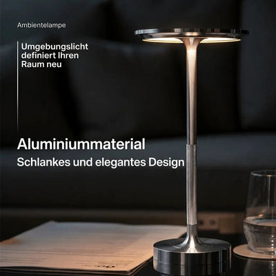 Elegante, schlanke Tischleuchte aus Aluminium, die ein angenehmes Umgebungslicht auf einen Tisch wirft.