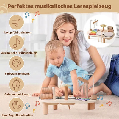 Mutter und Kind spielen gemeinsam mit einem Montessori-Schlagzeug, das Xylophon und weitere Klangelemente enthält.